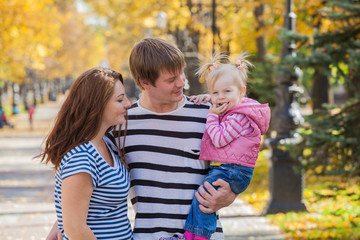 Fototapeta na wymiar happy family in the same clothes for a walk in the park in autumn