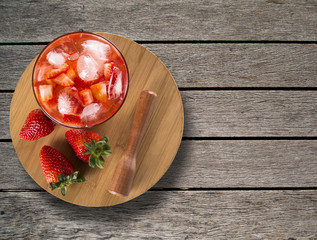 Fresh made Strawberry Caipirinha on wooden background