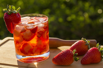 Fresh made Strawberry Caipirinha on green blurry background