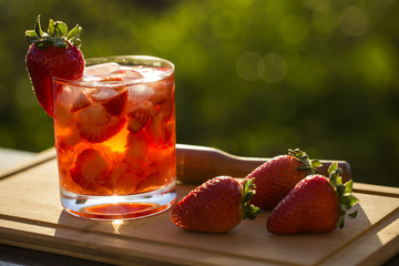 Fresh made Strawberry Caipirinha on green blurry background