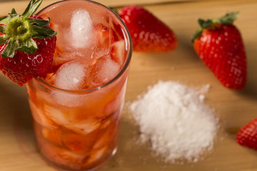 Fresh made Strawberry Caipirinha on wooden background