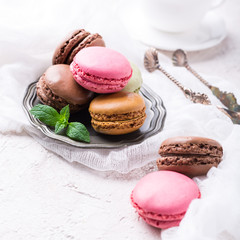 Colorful almond cookies macaron or macaroon on light background, vintage card, holiday food concept, copy space for text.