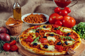 Pizza bolognese on a wooden board.