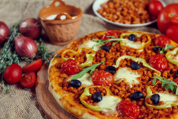 Pizza bolognese on a wooden board.