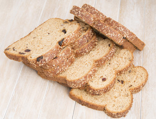 Whole wheat bread slices on wooden background