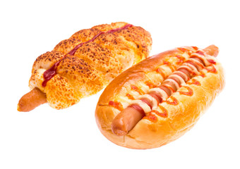 Two hot dogs with ketchup on white background