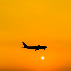 airplane silhouette over sunset