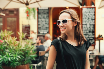 Smiling Woman on the Background of European Old Town Street.