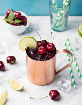 Cold cherry Moscow Mules cocktail with ginger beer, vodka, lime Marble background Copy space