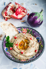 Traditional arabian eggplant dip baba ganoush with herbs and smoked paprika on a mosaic background