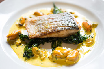 Cooked Fish Fillet on Spinach and Yellow Mussel Sauce