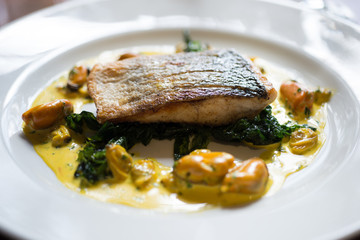 Fish Fillet on Spinach Leaves and Yellow Mussel Sauce