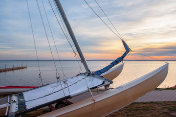 Closeup of a catamaran on a seashore at sunset.
