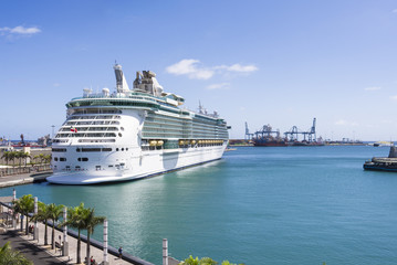 Giant cruise liner lying at the pier at blue skies and sun.