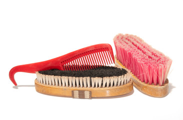 Two soft brushes and a comb-hoofpick combo for grooming horses
