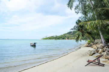 Sunbeds beside the tropical beach and ocean. Thailand.