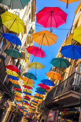 Fototapeta na wymiar Antique street decorated with colorful umbrellas.