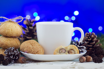 Cookies with nuts, tea and Christmas decoration on a blue bokeh background