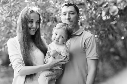 happy couple with daughter in park, black - white photo