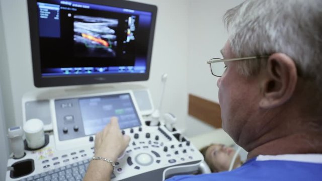 Doctor is using ultrasound machine to scan of a female patient