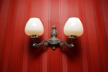 Vintage wall lamp on the red wallpaper background