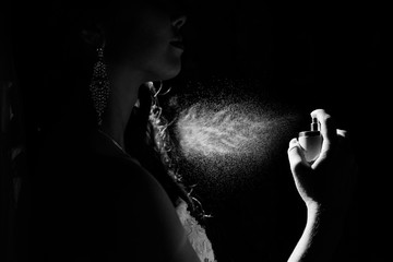 Woman push on parfume. Spray can with fume coming out on black background
