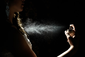 Beautiful woman enjoying a perfume on black background