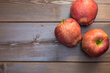 Three apples on the wooden table