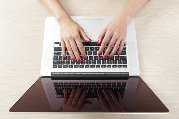 Fototapeta na wymiar Top view of hand typing on laptop keyboard