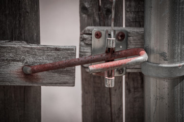 Rusted latch on wooden fence.