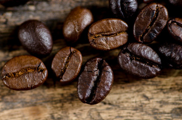 Close up arabica and robusta coffee beans roasted on wood background