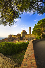 Fototapeta na wymiar Tuscany, Volterra town skyline, church and trees on sunset. Ital