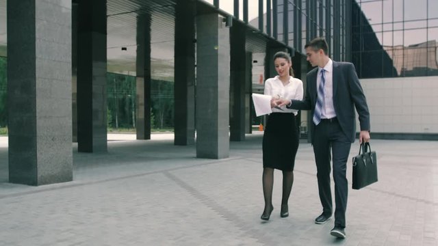 Successful businessman and attractive businesswoman discussing their project