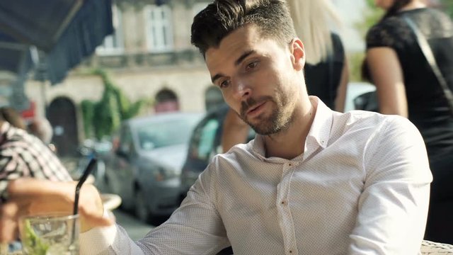 Man drinking mojito and receiving good news in the message
