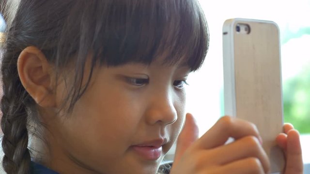 4K : Close up of Asian child playing game on smart phone
