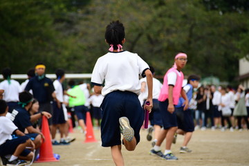 Students running in a field. Sports day in Japan.