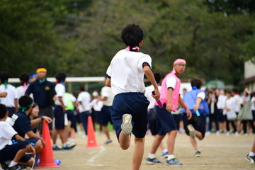Students running in a field. Sports day in Japan.
