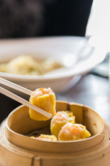 chopstick hold dimsum from bamboo containers