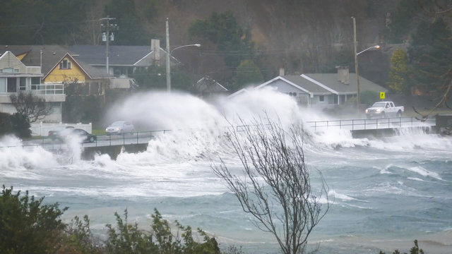 winter storm waves wash over road