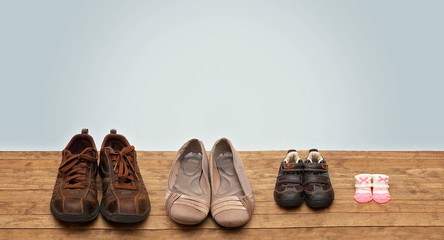 Family of Fours Shoes in a Row on a Wooden Surface