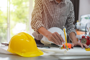 Architect working on blueprint. Architects workplace - architectural project, blueprints, ruler, calculator, laptop and divider compass. Construction concept