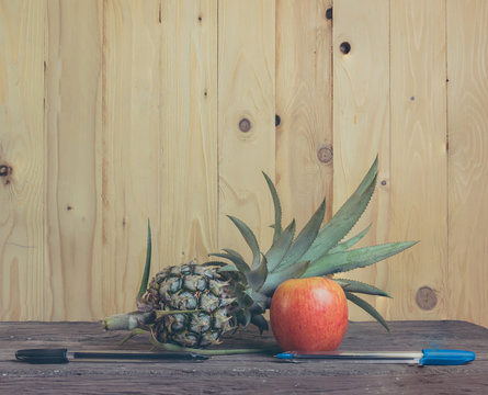 Pen-Pineapple-Apple-Pen on wooden background.