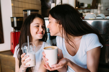 Mother and daughter drink espresso