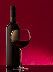 A glass and bottle of red wine