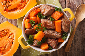 Braised beef with pumpkin closeup in the pan. Horizontal top view
