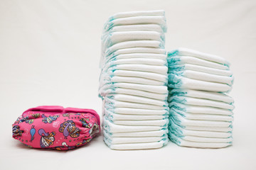 Stacks of disposable diapers and modern cloth diapers