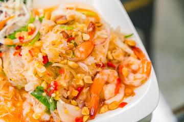 Spicy noodles with shrimp and vegetables .