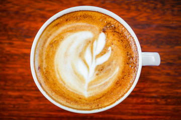 Latte Coffee art on the wooden table .