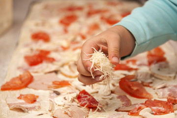 Children make Italian pizza. Cooking pizza with a kid