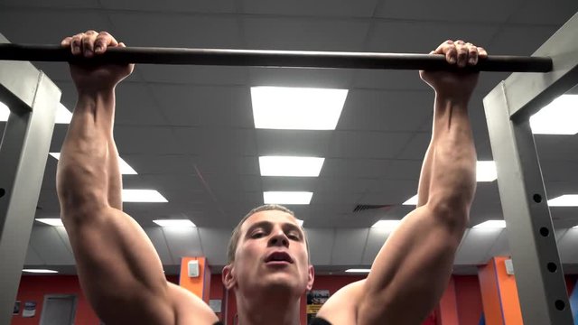 athlete pulls on the bar at the sport gym